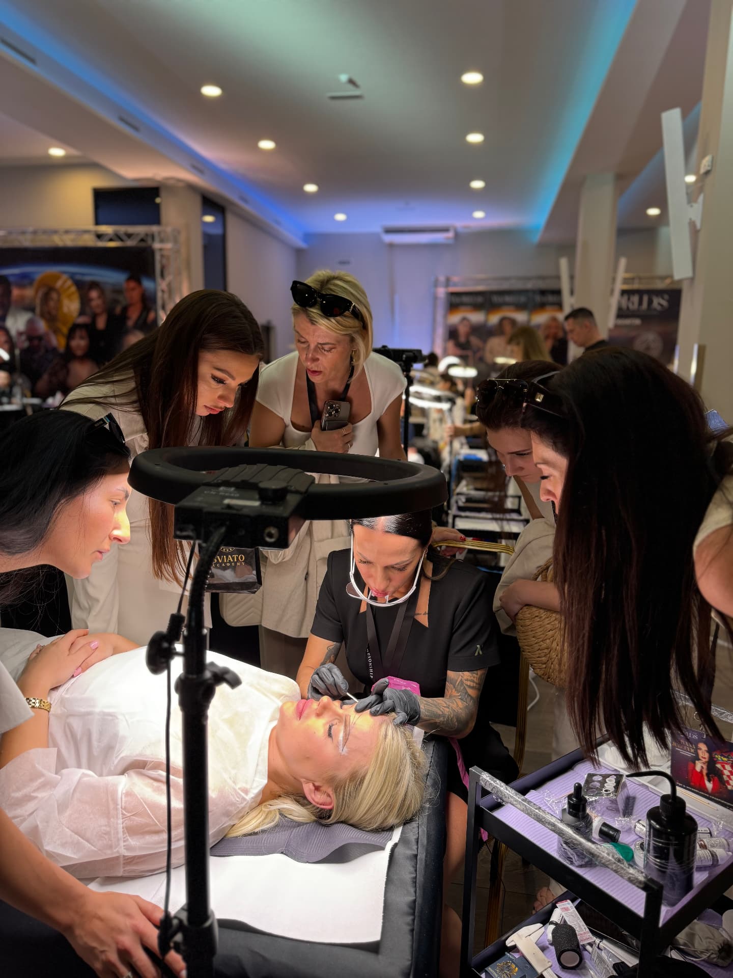 Students gathered around a permanent makeup demonstration